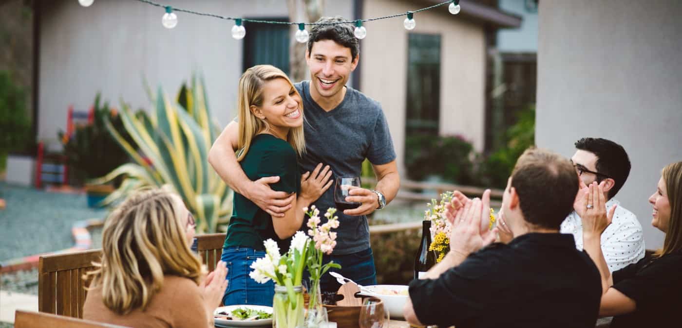 Couple toasting with friends at dinner