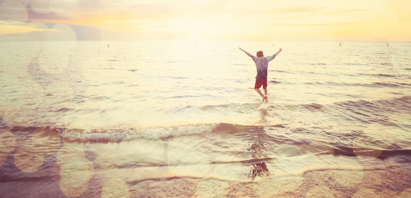 Boy happily playing by the shore