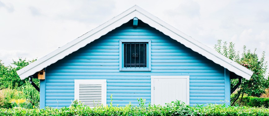 Blue house and a hedge