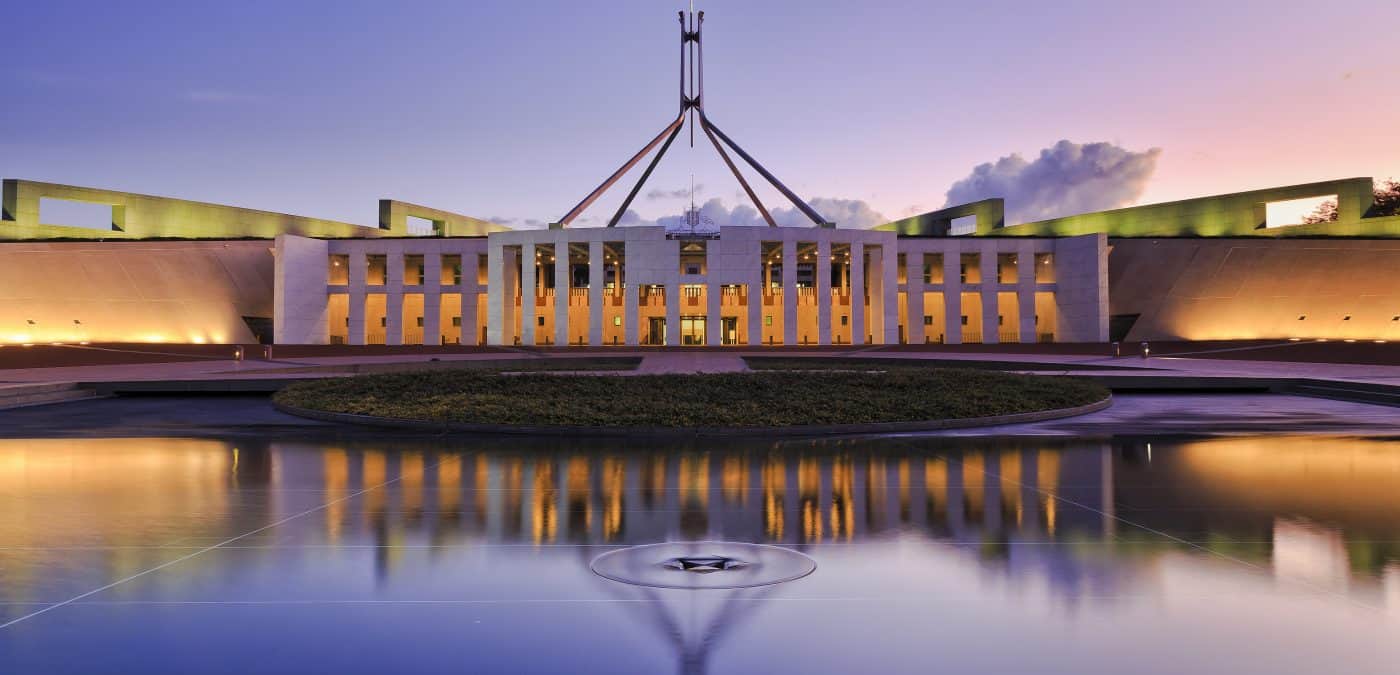 Colourful reflection of Canberra's new parliament building in a fountain pond at sunset.