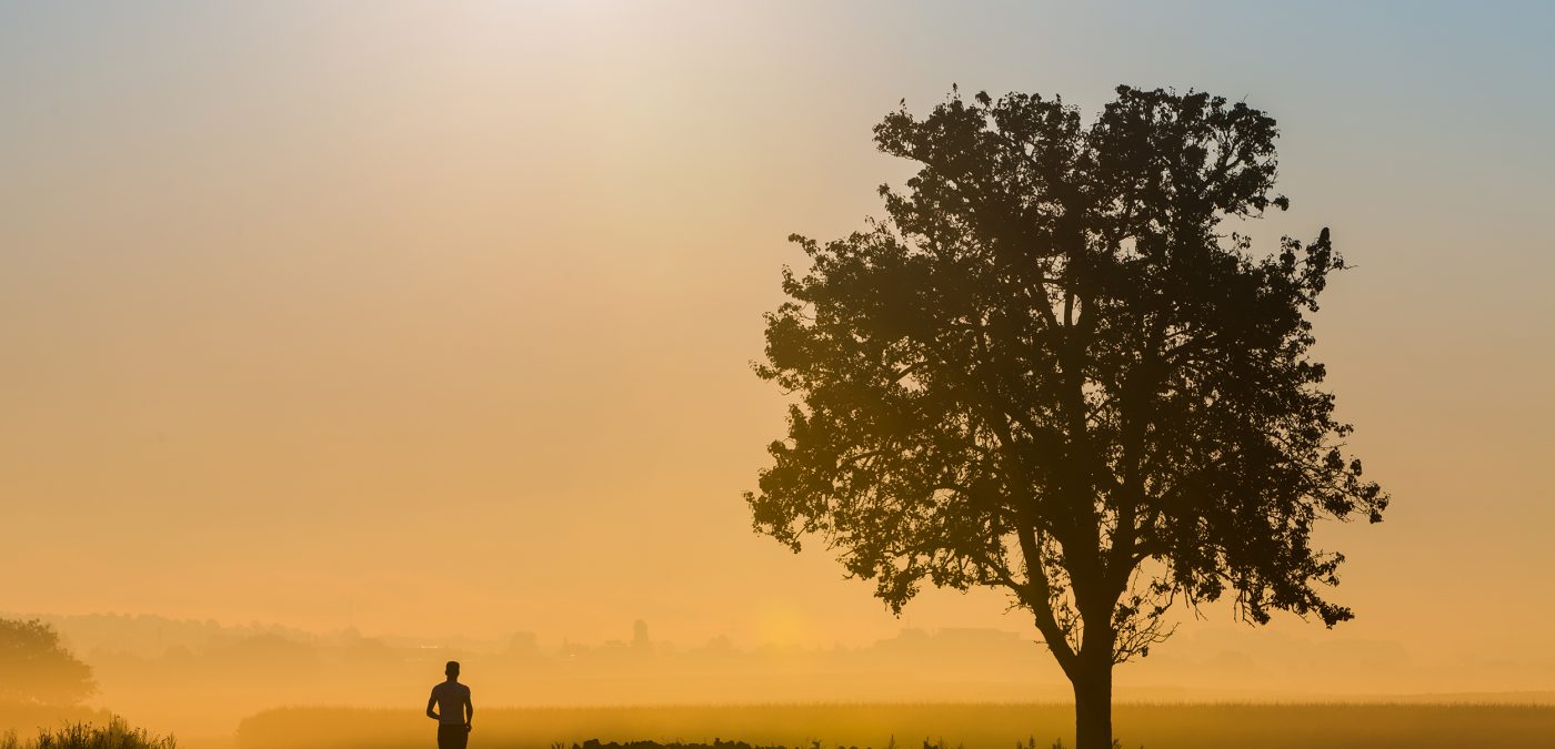 A sunset view with a boy cross country running