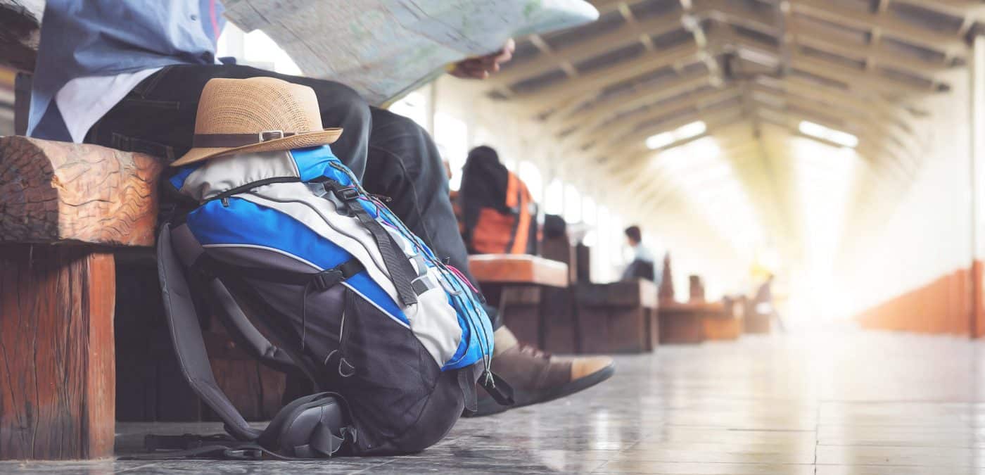 Backpack and hat at the train station with a traveler