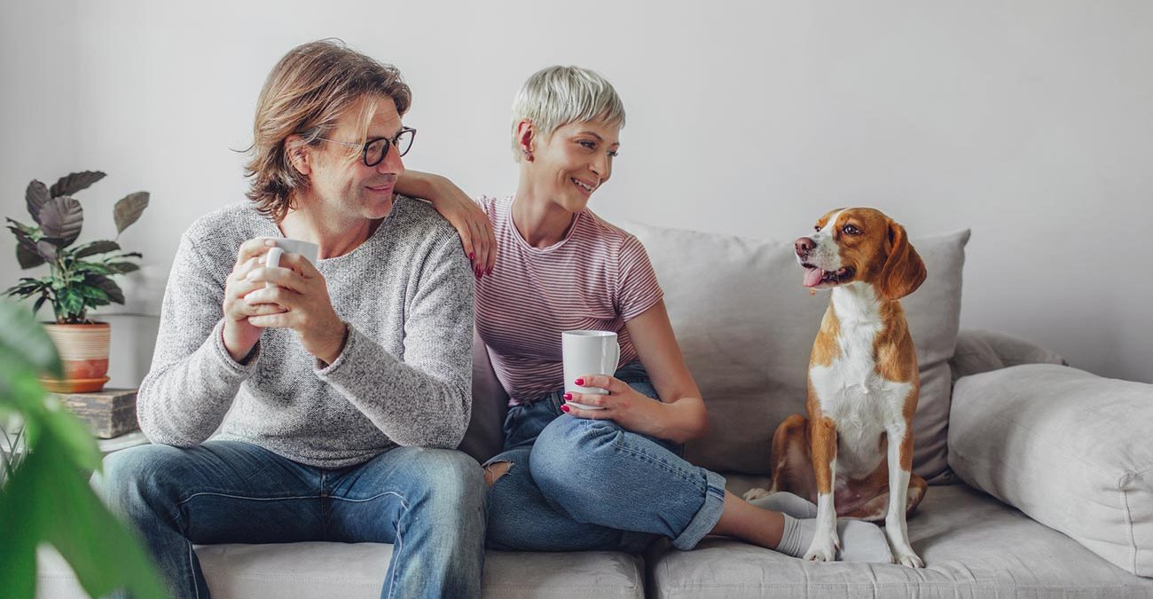 man, woman and dog on the couch