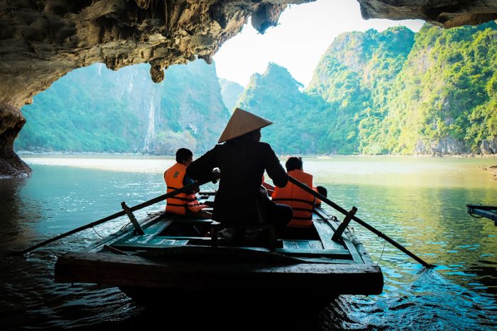 A young girl paddle's a bamboo boat for tourists in the beautiful bay in Vietnam.