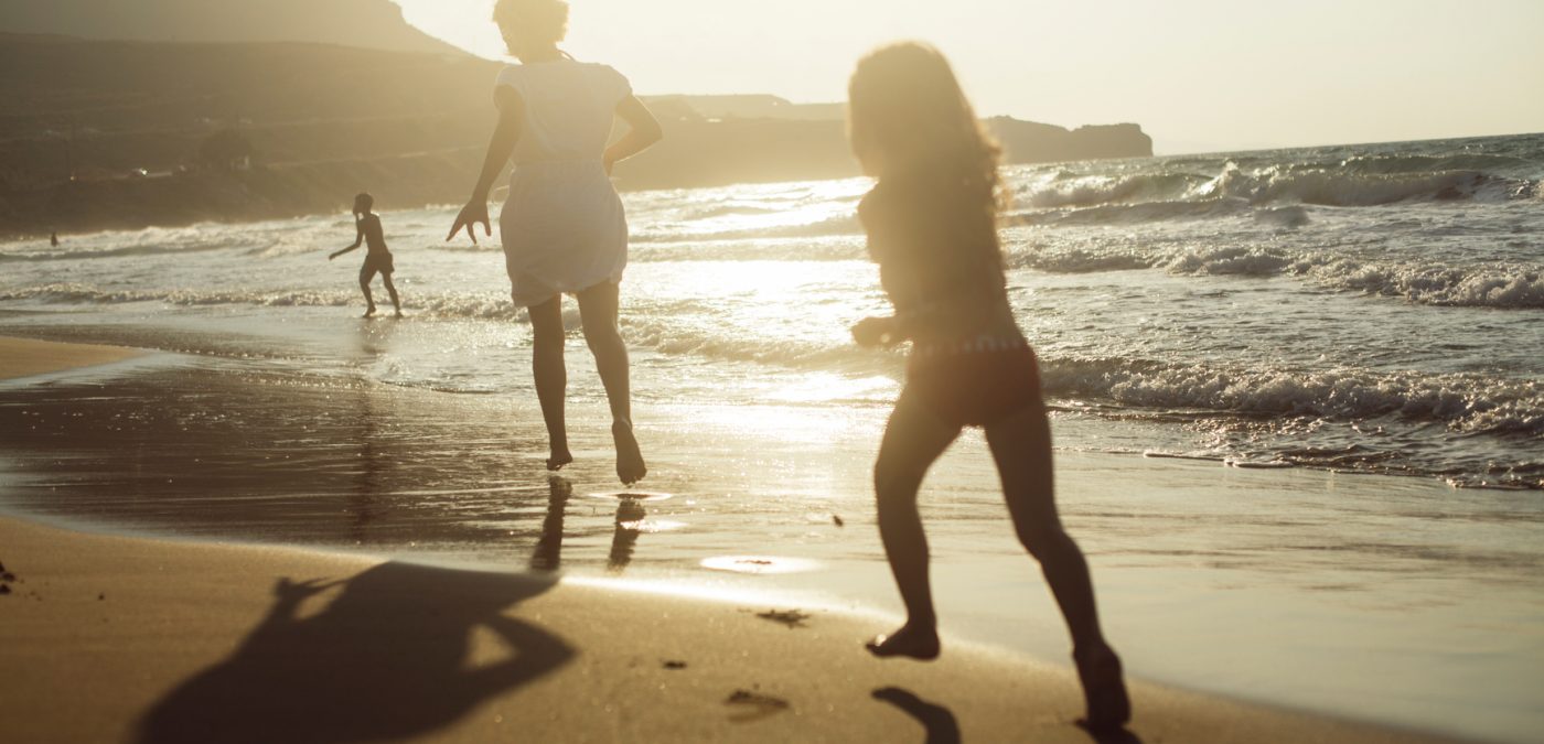 family playing on the beach at sunset