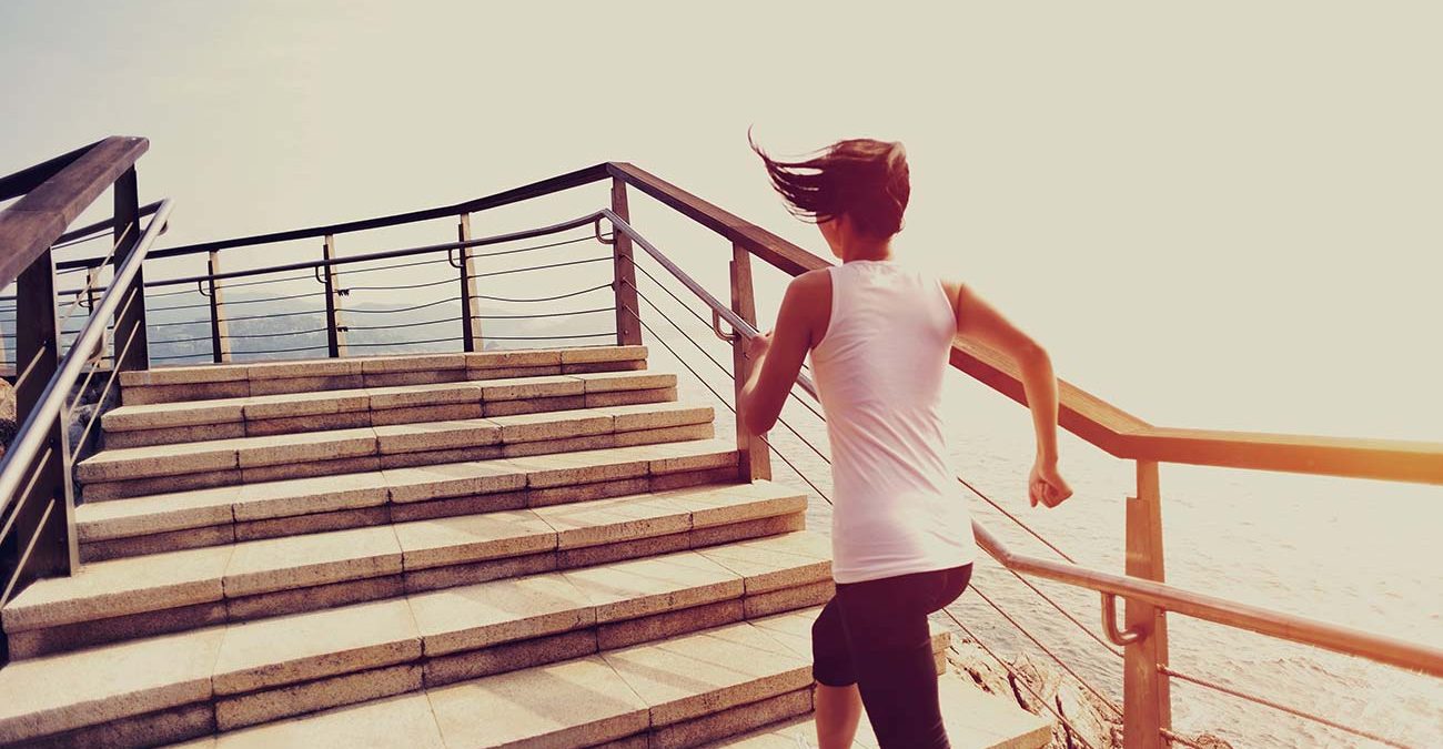 Runner athlete running on seaside stone stairs.