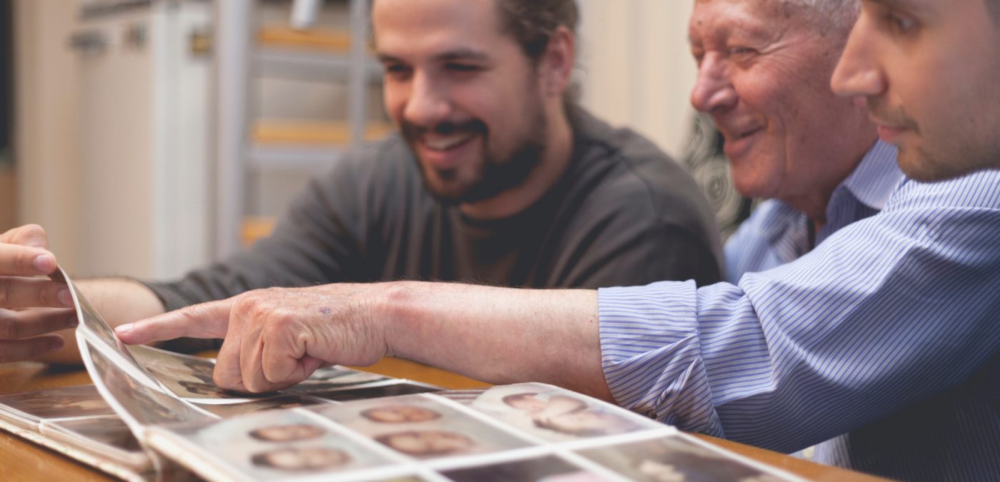 3 men looking over an old photo album