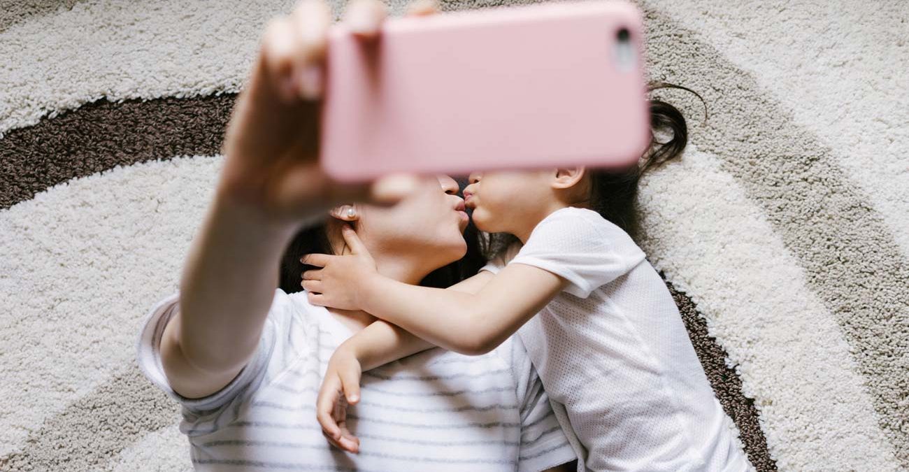 Adorable little girl with her mother taking selfie