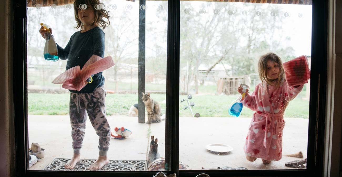 young girls helping with a spring clean cleaning the windows