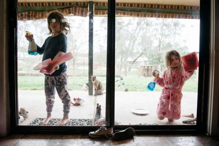 young girls helping with a spring clean cleaning the windows