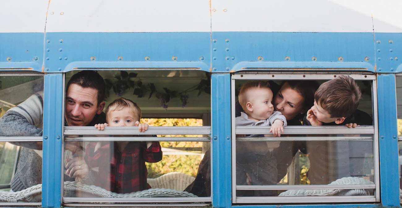 Young family of five looking out bus window