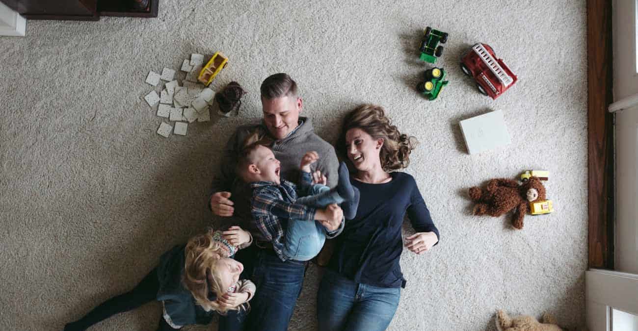 family of four playing on the floor together