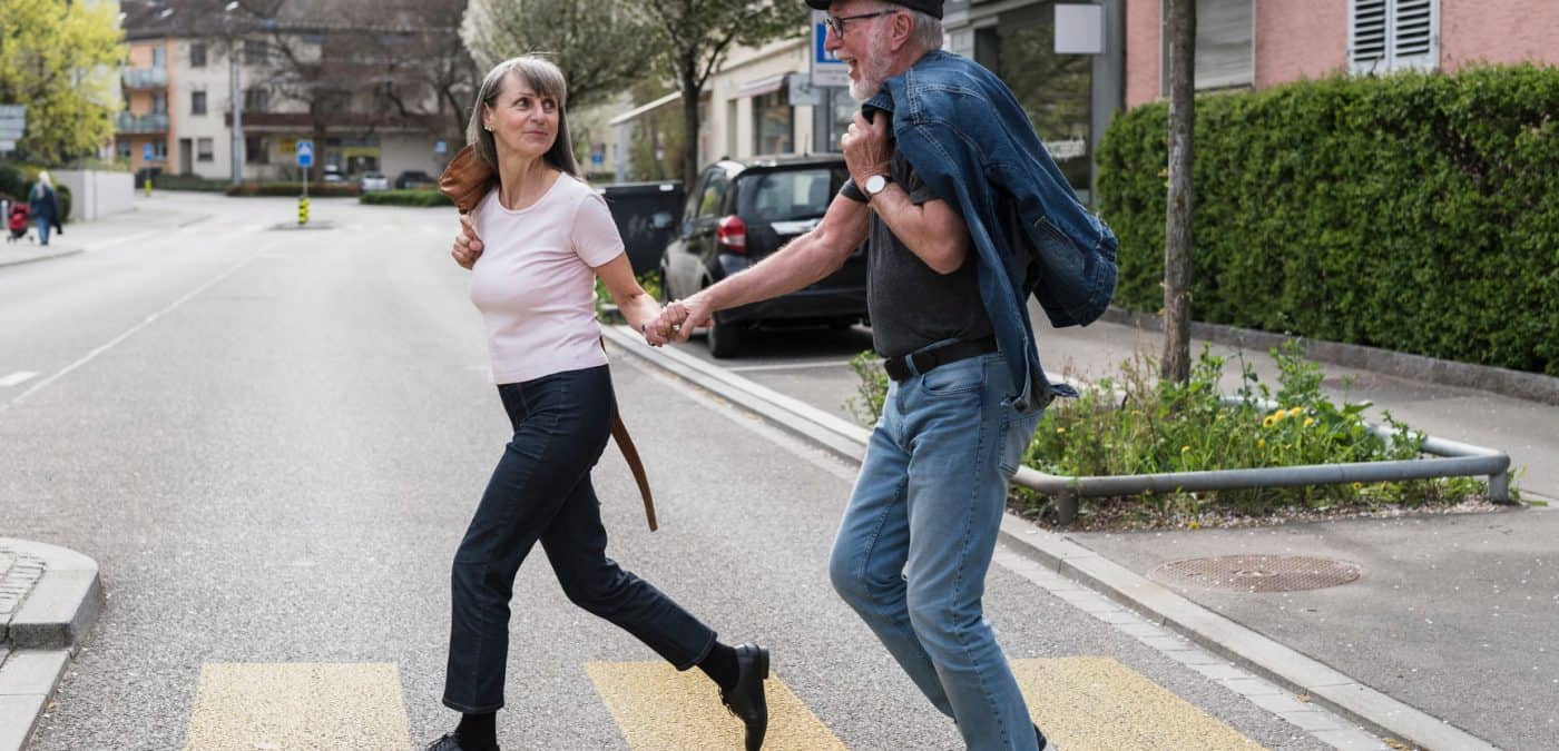 investblue -Senior couple walking on the street in the city.